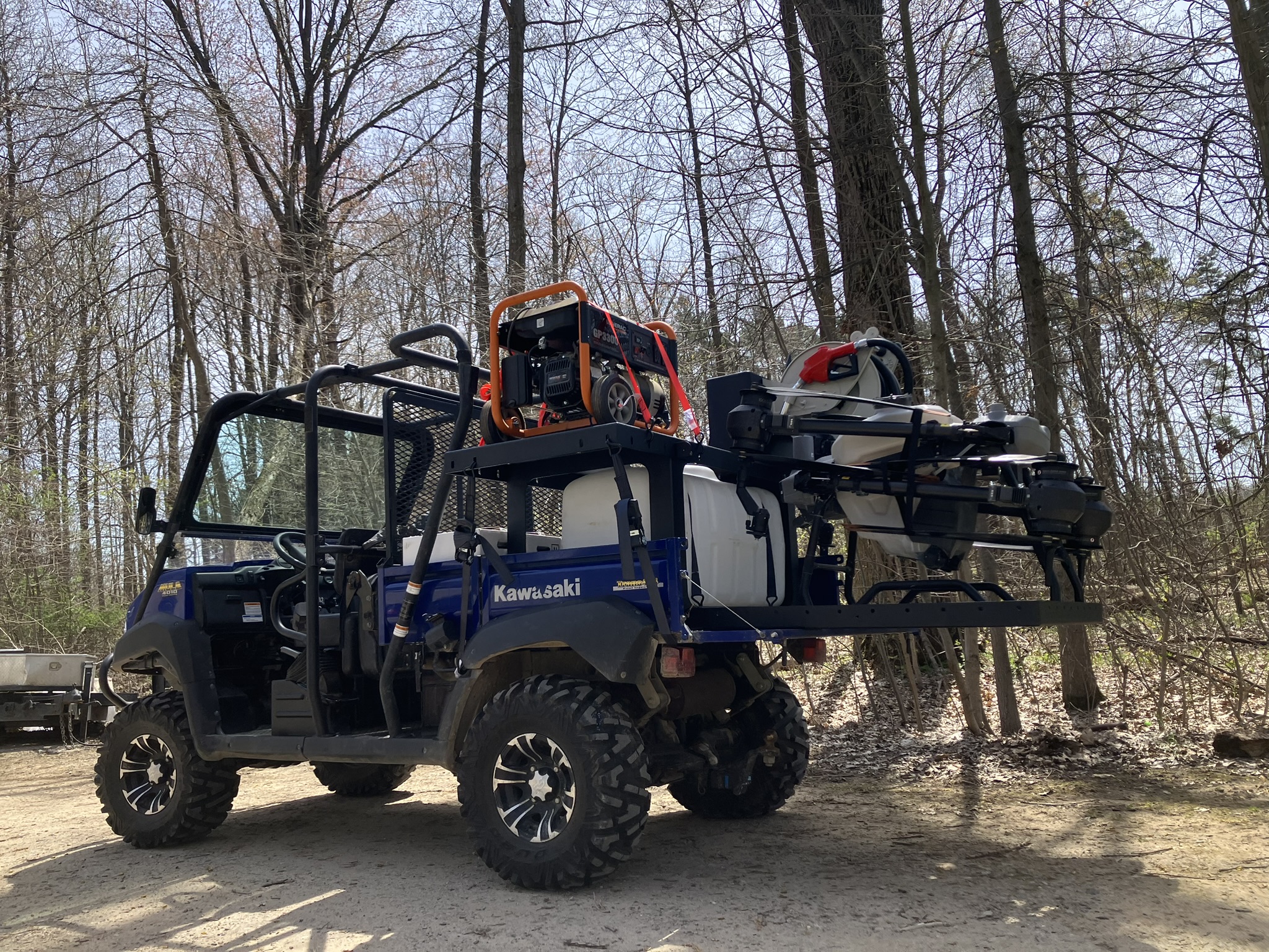 Compact drone spray trailer mounted in a UTV bed for agricultural drone operations