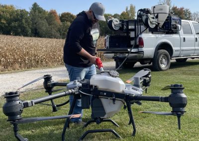 Agricultural spray drone being refilled in the field with a tender system