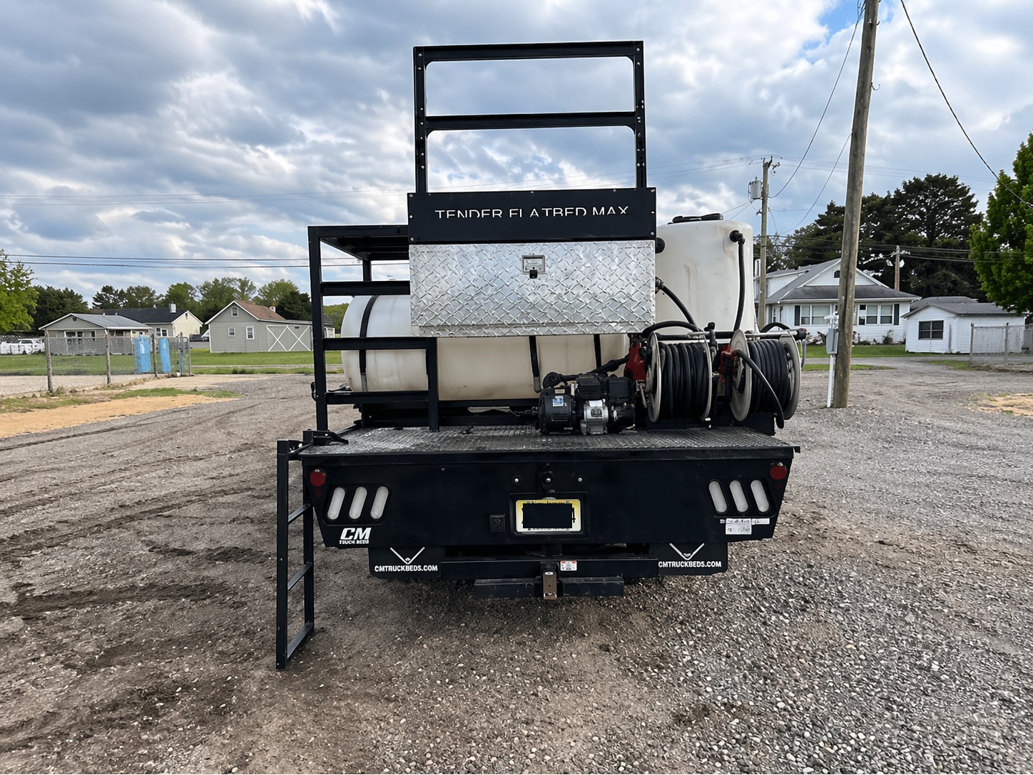 Flatbed Max truck-mounted tender rear view showing tank, pump, and dual hose reel system